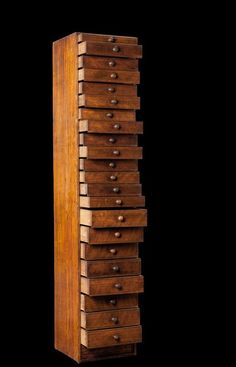 a tall wooden cabinet with many drawers on it's sides and one drawer open