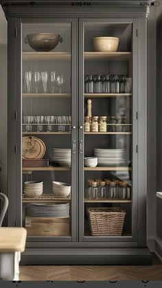 a glass door cabinet in a kitchen filled with dishes