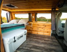 the interior of an rv with wood paneling and storage area, including a bed