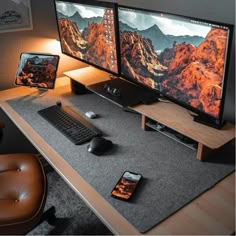 two computer monitors sitting on top of a desk next to a keyboard and monitor screen