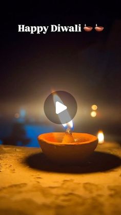 happy diwali greeting card with an orange bowl and lit candles in the background