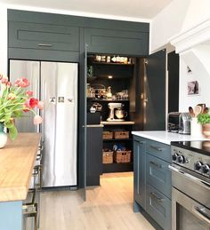 a kitchen with an oven, refrigerator and flowers in vases on the counter top