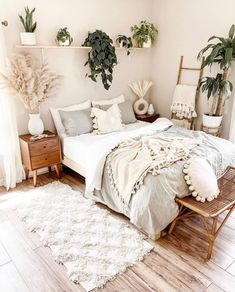 a bedroom with plants on the wall and a bed in the middle, surrounded by white rugs