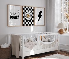 a baby's room with two posters on the wall and a crib next to it