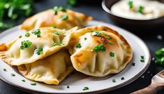 some dumplings are on a plate with green garnishes next to it