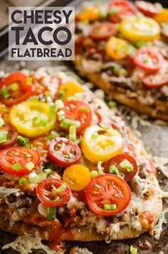 two pizzas with tomatoes, onions and cheese are on a baking sheet ready to be eaten