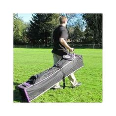 a man carrying a large bag in the grass