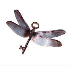 a metal key with a dragonfly on it's back and wings hanging from the end