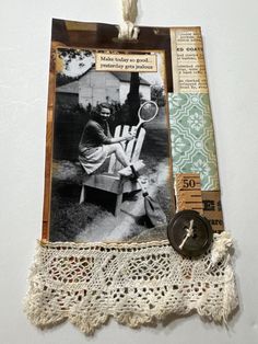 an old photo is hanging on the wall next to a lace doily with a button