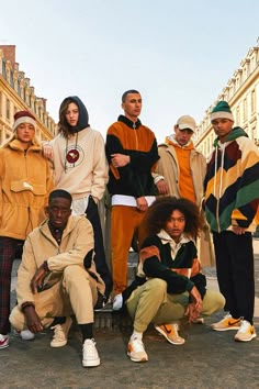 a group of people standing next to each other in front of a building on the street