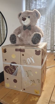 a teddy bear sitting on top of a box