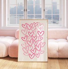 a painting on the floor in front of a window with pink hearts painted on it