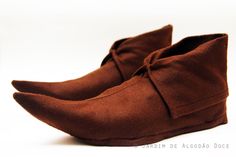 a pair of brown shoes sitting on top of a white surface