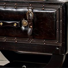 an old fashioned trunk is sitting on the floor next to a door and window sill