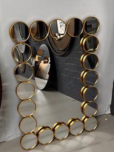 a mirror that is sitting on top of a table next to a brick wall with circles around it