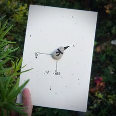 a person holding up a piece of paper with a drawing on it