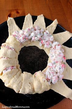 a bundt cake decorated with sprinkles and frosting on a black plate