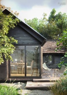 a small wooden house sitting next to a lush green forest