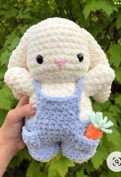 a crocheted bunny holding a carrot in its hand