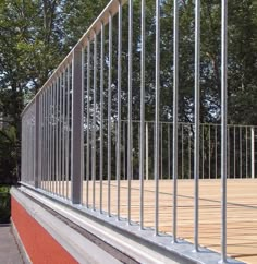 a metal railing on the side of a building with trees in the backround