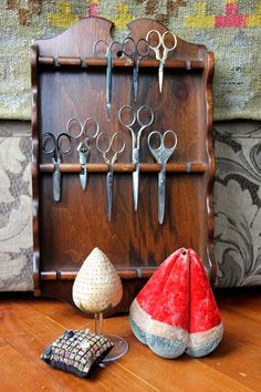 there are many pairs of scissors hanging on the wall next to some knick - knacks