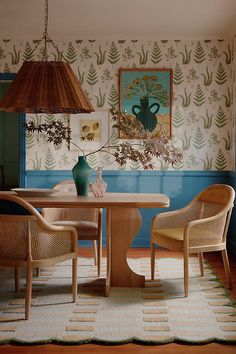 a dining room table with two chairs and a lamp