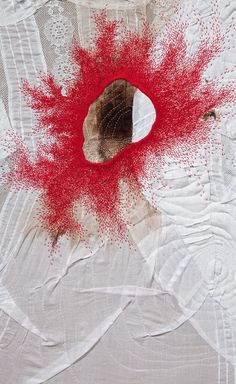 a piece of art with red paint splattered on it