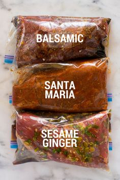 three packages of food sitting on top of a marble countertop with the words balsamic, santa maria and sesame ginger