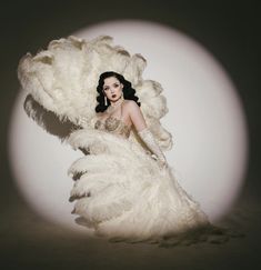 a woman in a white feathered dress posing for a photo