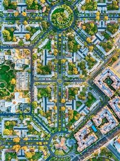 an aerial view of a city with lots of streets and trees in the middle of it