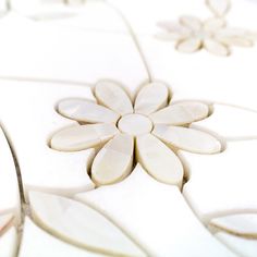 a close up view of a flower design on a tile floor with white and beige colors