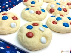 cookies decorated with red, white and blue candies are on a plate next to a polka dot tablecloth