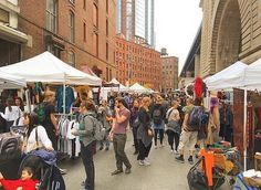 many people are shopping at an outdoor market