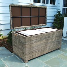 a large wicker chest sitting on the side of a house