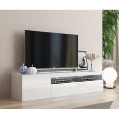 a flat screen tv sitting on top of a white entertainment center in a living room