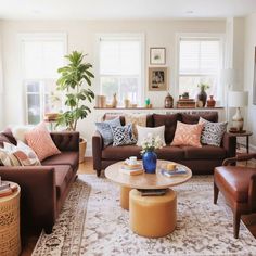 a living room filled with lots of furniture and pillows on top of a carpeted floor