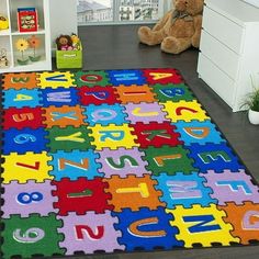 a child's rug with letters and numbers on it in the middle of a room