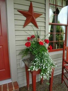 a potted plant sitting on top of a wooden bench next to a red door