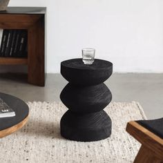 a black table sitting on top of a rug next to a chair and coffee table