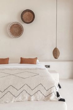 a white bed with two hanging baskets above it