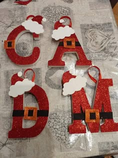 the letters are made out of glitter and santa's helper hats on top of each other