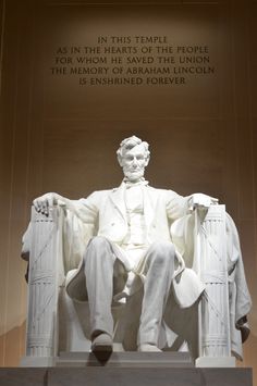 the lincoln memorial is lit up at night and has a statue of abraham lincoln on it