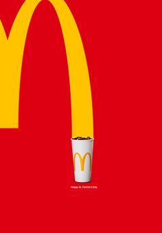 a mcdonald's cup is sitting in front of a red background with a yellow and white logo