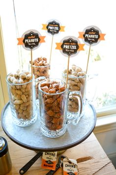 desserts are displayed in glass mugs on a tray with stickers and labels