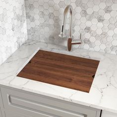 a wooden cutting board sitting on top of a kitchen counter next to a faucet