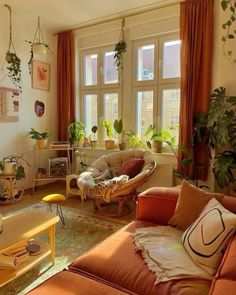 a living room filled with lots of furniture and plants on the windows sills