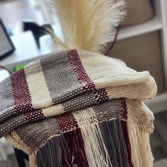 a chair with a plaid blanket on top of it and a feather sticking out of the back