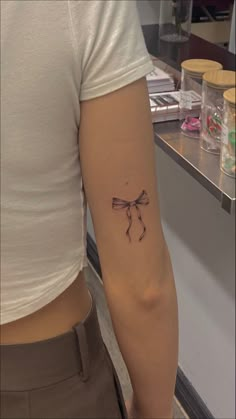 girl with bow tattoo on the back of the arm, bow tattoo, womens fine line tattoo Small Bow Tattoo, Tattoo Lace, Petit Tattoo, Discreet Tattoos