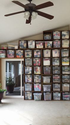 a ceiling fan sitting above a wall filled with boxes