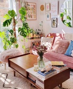 a living room filled with furniture and lots of plants